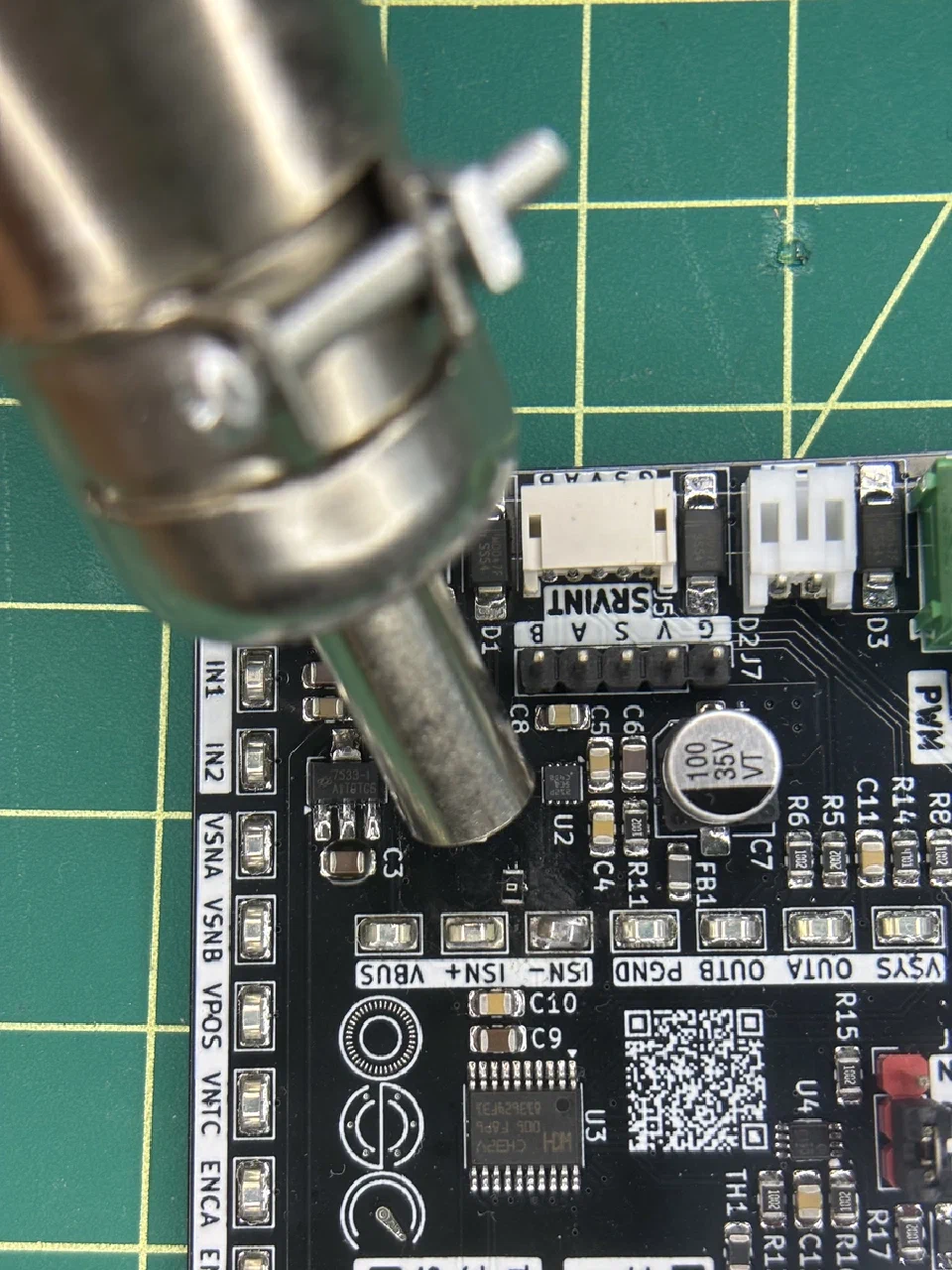 Hot air aimed at the 0805 0 Ω resistor bridging the SB1 cut, mid-rework